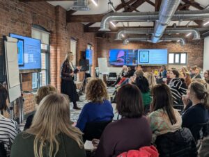 Speaker presents to audience at Helping the Helpers event