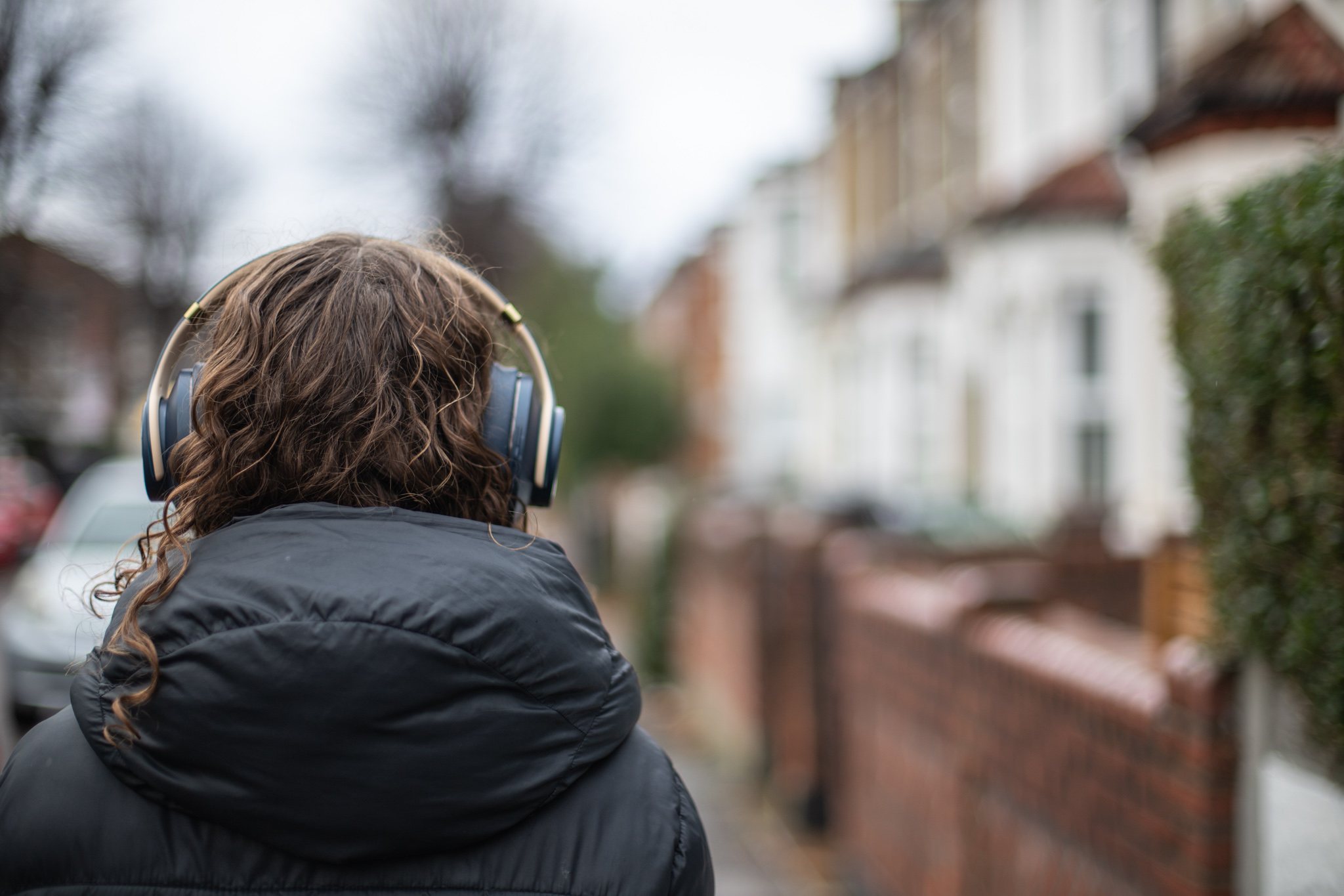 girl in puffer coat with headphones on